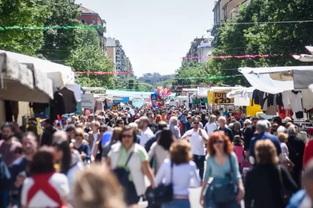 Mercato affollato con bancarelle e vivace partecipazione nel centro città.